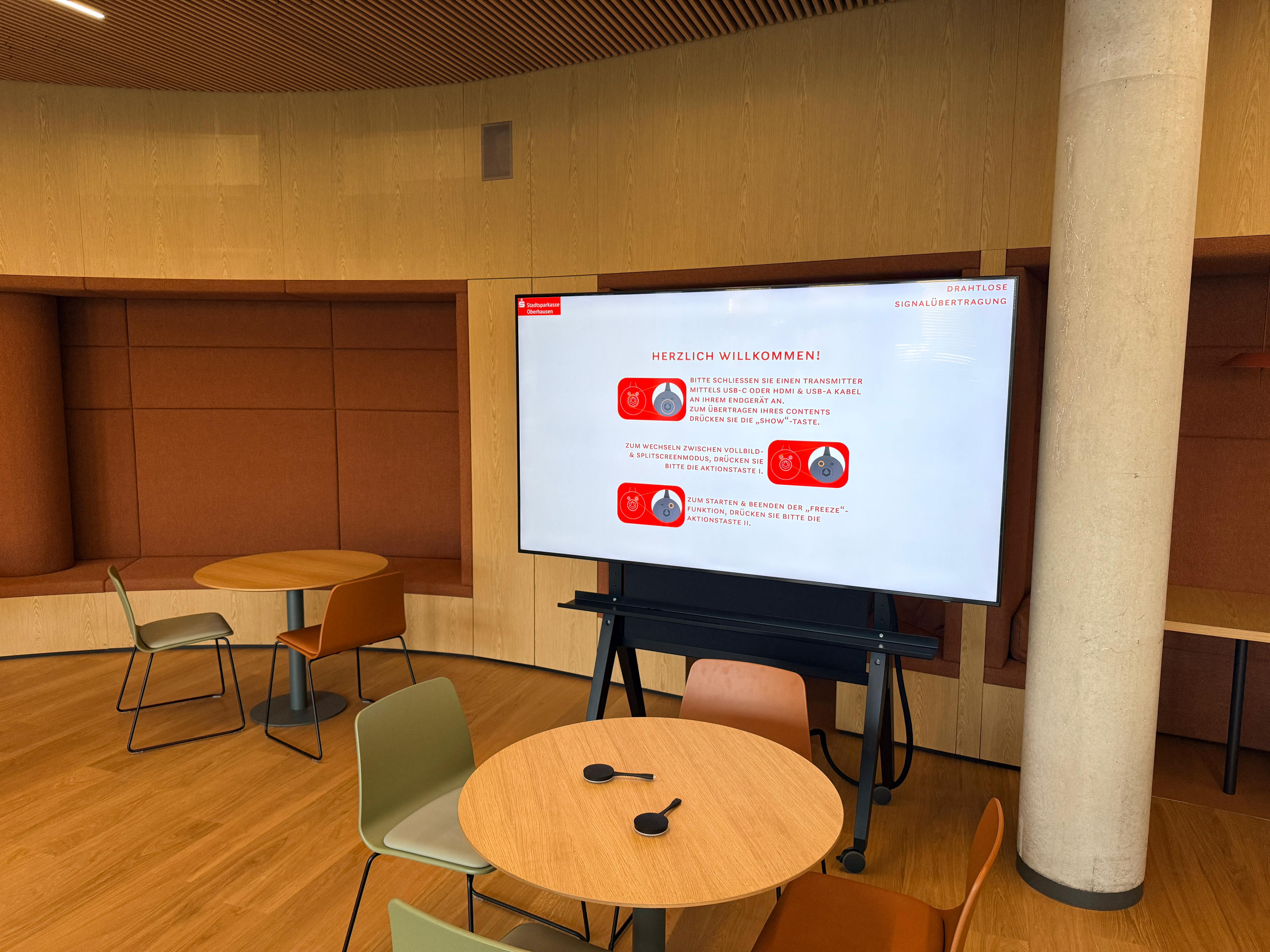Cafeteria Sparkasse Oberhausen – Großformat-Display mit Lightware Signalübertragung und runde Tische