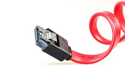 SATA-Datenkabel – Festplatten- und SSD-Verbindung Rotes SATA-Datenkabel mit gewundenem Design und schwarzem Anschlussstecker mit Metallclip, auf weißem Hintergrund.