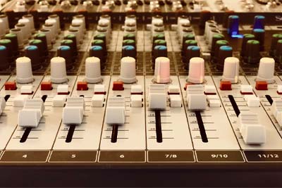 Mischpult – Professionelle Tontechnik & Live-Sound Professionelles Audiomischpult mit mehreren Kanälen, Fadern und farbigen Drehreglern für Tontechnik und Live-Sound.